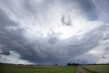Fototapeta na wymiar upcoming big tunderstorm with amazing dark clouds over the field