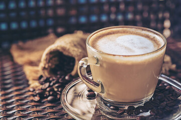 Coffee cup latte art and cappuccino with heart-shaped made from milk on the wood table with roasting coffee beans.