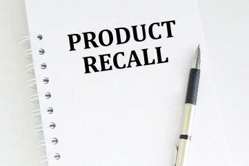 Text Product Recall on a page notepad on a light table next to a pen. Business concept