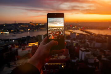 Istanbul at sunset, Turkey. Taking a photo cityscape by cell phone.