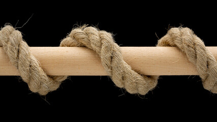 Hemp rope wrapped around wooden dowel rod isolated on black background