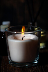 Obraz na płótnie Canvas burning aroma candle on a dark background, closeup vertical