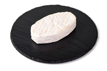 Camembert cheese on black round slate stone plate, isolated on white background
