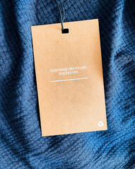 Contains recycled polyester fashion label tag, sale price card on luxury fabric background,...