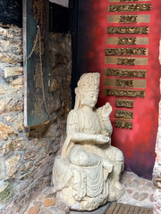 Rye, England, UK. Sitting Buddha sculpture in the corner of asian decorated place in Rye, Mermaid street, East Sussex, England. 