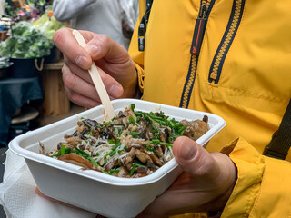 Takeaway food. Middle aged man tourist is eating mashroom risotto at food market. Eating healthy. Takeaway food. Middle aged man tourist is eating mashroom risotto at food market. Eating healthy