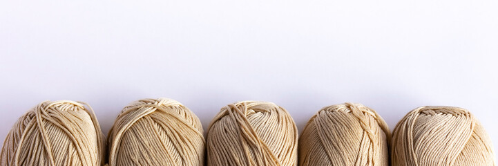 Fototapeta na wymiar Beige yarn threads on a white background for knitting. Flat lay