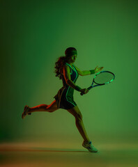 Fototapeta na wymiar Tennis player with racket in sportswear. Woman athlete playing dark background.