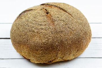 Healthy lifestyle. Delicious wholegrain bread on a white wooden background. Delicious bread crust texture. Proper nutrition. Close-up.