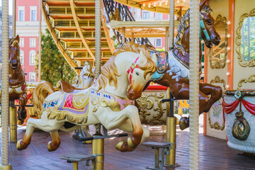 Children's vintage carousel with figures of horses. A working carousel without people. Colorful...