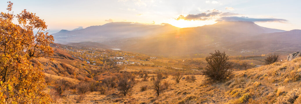 Panoramic view of the mountain valley illuminated by the rays of the sun
