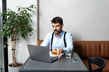 Young successful business man freelancer with good mood using laptop computer for distance work...