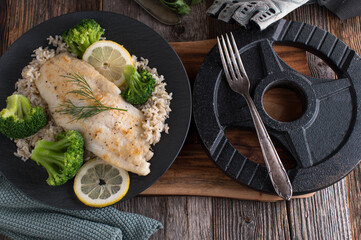 Fitness meal with fish, brown rice and broccoli on a plate