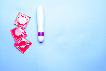 female dildo and condoms for sex shot from above on a light blue background horizontally - obrazy, fototapety, plakaty