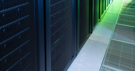 Image of empty corridor with row of green and blue computer servers