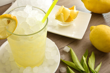 Detail of lemon beverage with ice on wooden table elevated