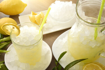 Lemon drink with ice on table and white isolated background