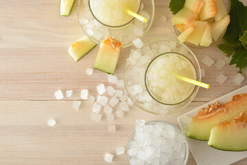 Glasses with iced melon drink and cut fruit top view