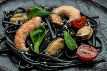 Pasta black spaghetti with prawn and mussels seafood. on dark background. Black spaghetti. banner, menu, recipe place for text, top view
