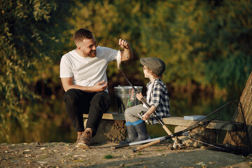 Young father teaching his little toddler son how to fish
