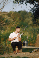Young man sitting on a bench and fishing