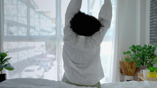 african girl American is lazily twisting in her bed in the morning, happy home concept.
