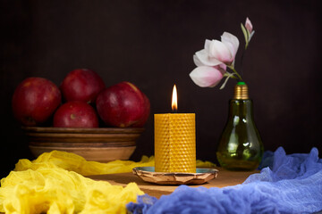 Decorative candle made of beeswax with a honey aroma for interior against the background of tradition colors of the Ukrainian flag (blue and yellow)