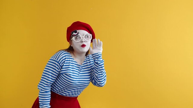 Concept of gossip, a female mime bends down and puts her hand to her ear eavesdropping on someone else's conversation, closing mouth in surprise, against an orange background