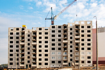 Fototapeta premium Construction of a residential building made of concrete blocks. View of the facade of an unfinished building.