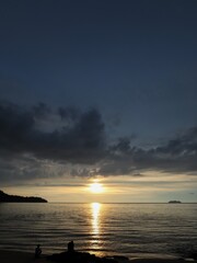 sunset over the sea with silhouette of a people