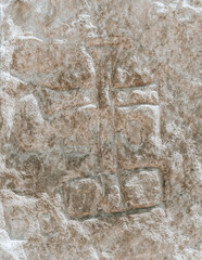 Large ancient rock with the cross carved in stone. Natural stone texture close up. Abstract organic background.