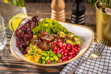 Salad bowl with fresh tofu, avocado, lettuce, grenade apple and mango