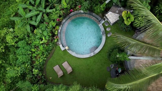 Aerial Birds Eye View Of Round Swimming Pool At Tropical Forest Retreat In Ubud. Pedestal Up, Establishing Shot 