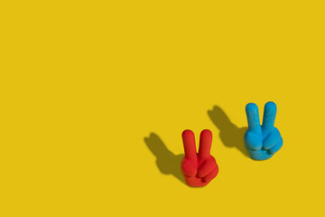 Obraz premium Red and blue eraser with two fingers up and a rabbit shadow on a yellow background.
