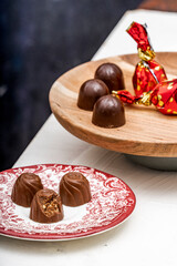 Almond and cherry liquor chocolate bonbons over white and black wooden background