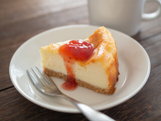 苺のソースをかけたベイクドチーズケーキとコーヒー