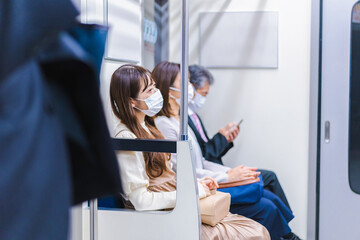 マスクをして電車に乗る人々