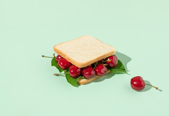 Sandwich made of red cherry berries on pastel background.  Creative heathy snack, food, fruit or vegetarian concept. Summer trend shadows. Pop art.