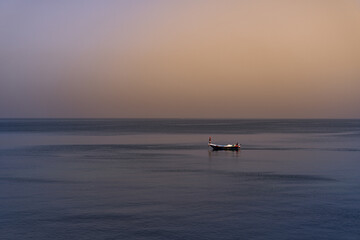 A boat in the middle of the sea at sunset in Alexandria Egypt
