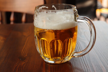 glass with handle full of light beer with foam
