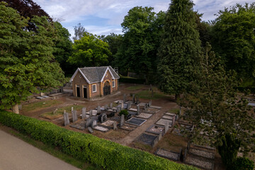 Small cemetery seen from above with greenery park and hedge surrounding it