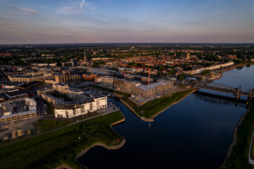 Luxury apartment complex construction at riverbank of river IJssel between train tracks and recreational port. Aerial panorama of the new Kade Zuid residential urban housing project