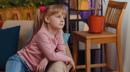 Sad little teen child girl looks pensive thinks over life concerns, suffers from unfair situation, divorce of parents, bullying. School toddler kid at home alone. Problem depressed feeling bad annoyed