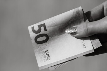 Giving money like a bribe or tips. Holding EURO banknotes in black and white
