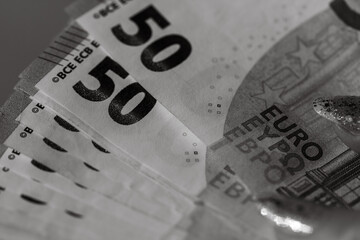 Giving money like a bribe or tips. Holding EURO banknotes in black and white