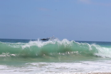 rough surf crashes a shoreline of a beach