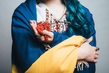 viburnum in the hands of a Ukrainian girl close-up. white embroidery. photo in studio on a white...
