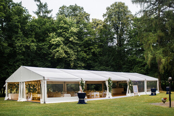 Long white tent for wedding party in the wood - obrazy, fototapety, plakaty