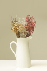 Ceramic jug with bunch of various dried flowers and plants
