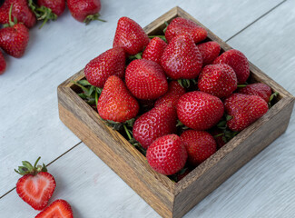 Strawberries in the wooden box on the kitchen table